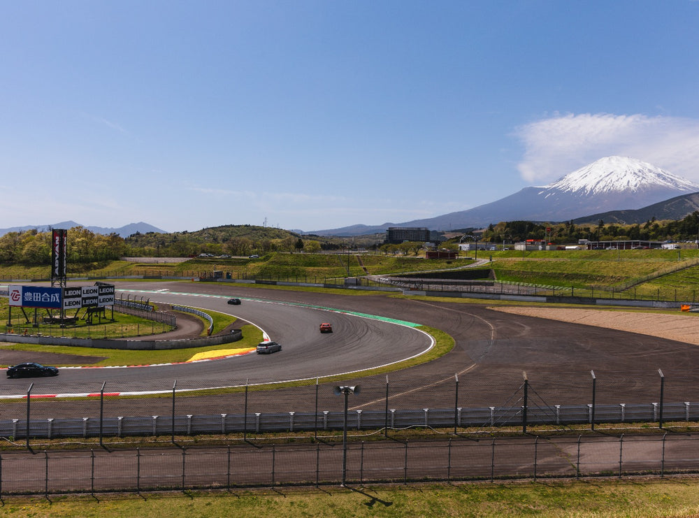 Cars lapping Fuji Speedway with Mount Fuji behind
