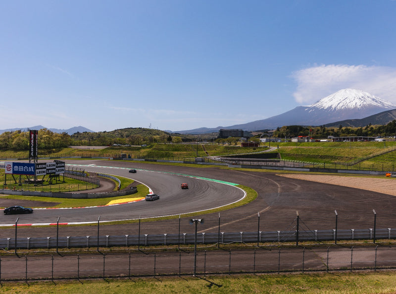Cars lapping Fuji Speedway with Mount Fuji behind
